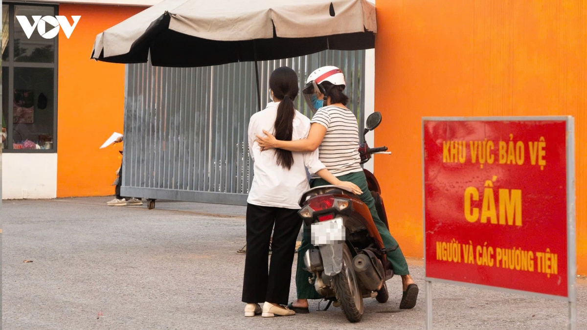 Phụ huynh ôm con động viên trước cổng điểm thi Trường THPT Chuyên Tuyên Quang sáng 14/8. Với nhiều gia đình, áp lực lớn nhất không chỉ là việc phải thi lại mà còn là tâm lý của các em khi bước vào kỳ thi đã từng trải qua; một số thí sinh tự tạo áp lực, lo kết quả lần này thấp hơn lần trước.