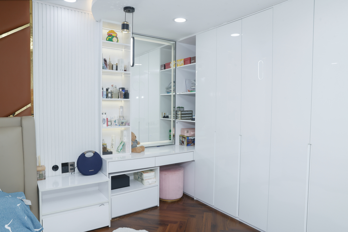 Cặp sao thiết kế hệ tủ màu trắng cao kịch trần, tối ưu hóa cho việc chứa nhiều trang phục. Khu vực bàn trang điểm bày nhiều mỹ phẩm, nước hoa của cả hai.