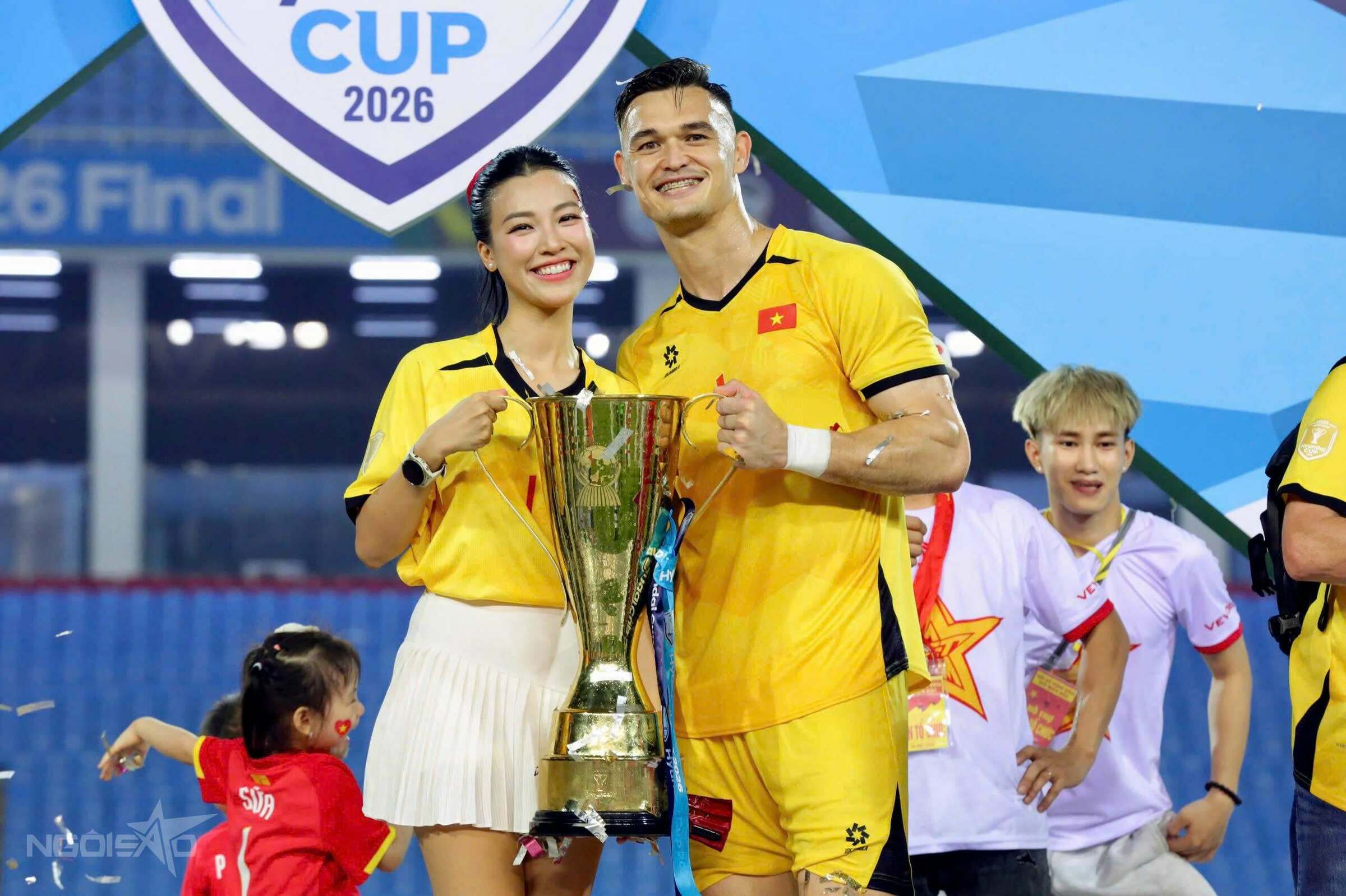 Patrik cùng bạn gái nâng cúp vô địch trên sân Mỹ Đình tối 26/8. Hoàng Oanh cũng diện chiếc áo màu vàng in tên bạn trai để thể hiện sự ủng hộ dành cho anh. Ảnh: Đức Đồng