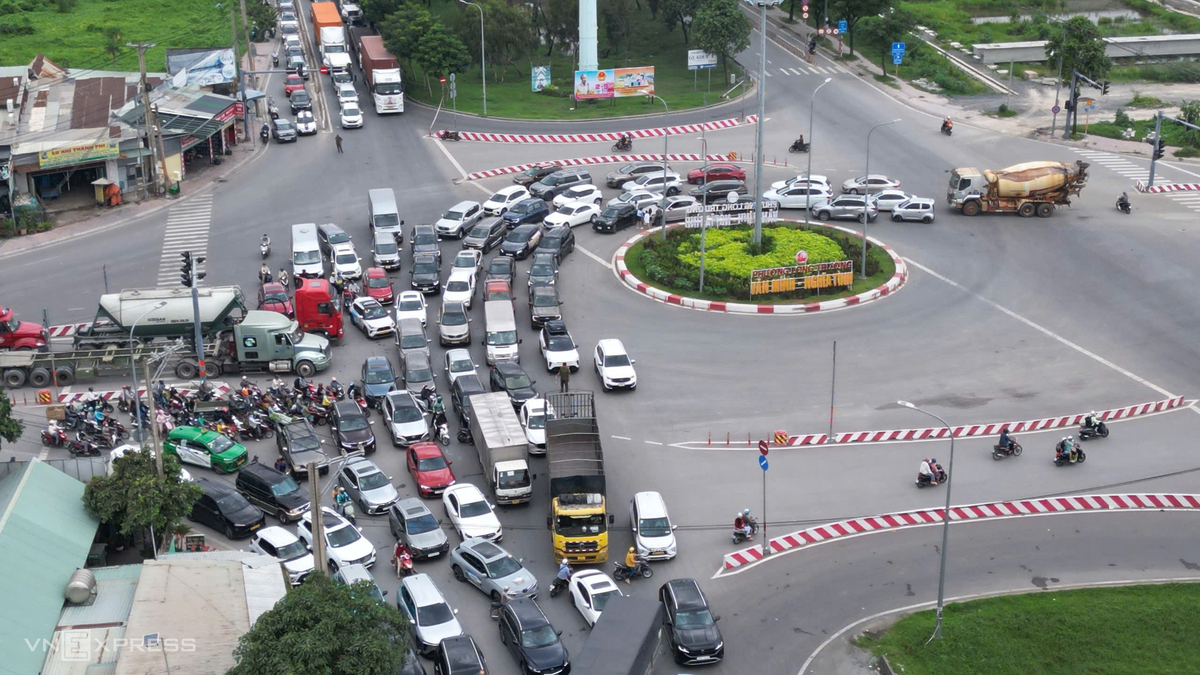 Tại vòng xoay Phú Hữu, dòng xe ken đặc, nhích từng chút một qua nút giao. Nhiều CSGT được bố trí tại các hướng để phân luồng, điều tiết giao thông.