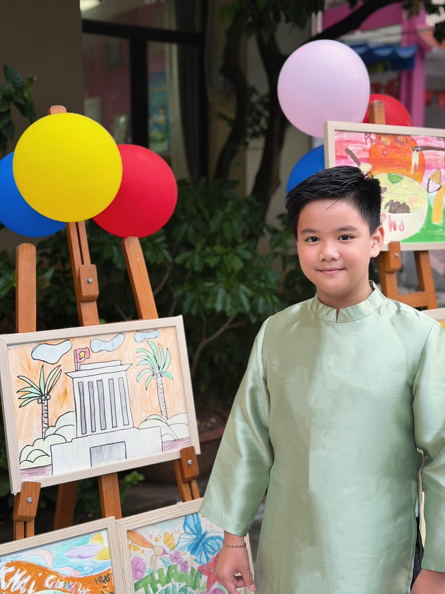 Con trai Trang Nhung tự hào khoe với bố mẹ bức tranh được trưng bày tại sân trường trong lễ khai giảng.