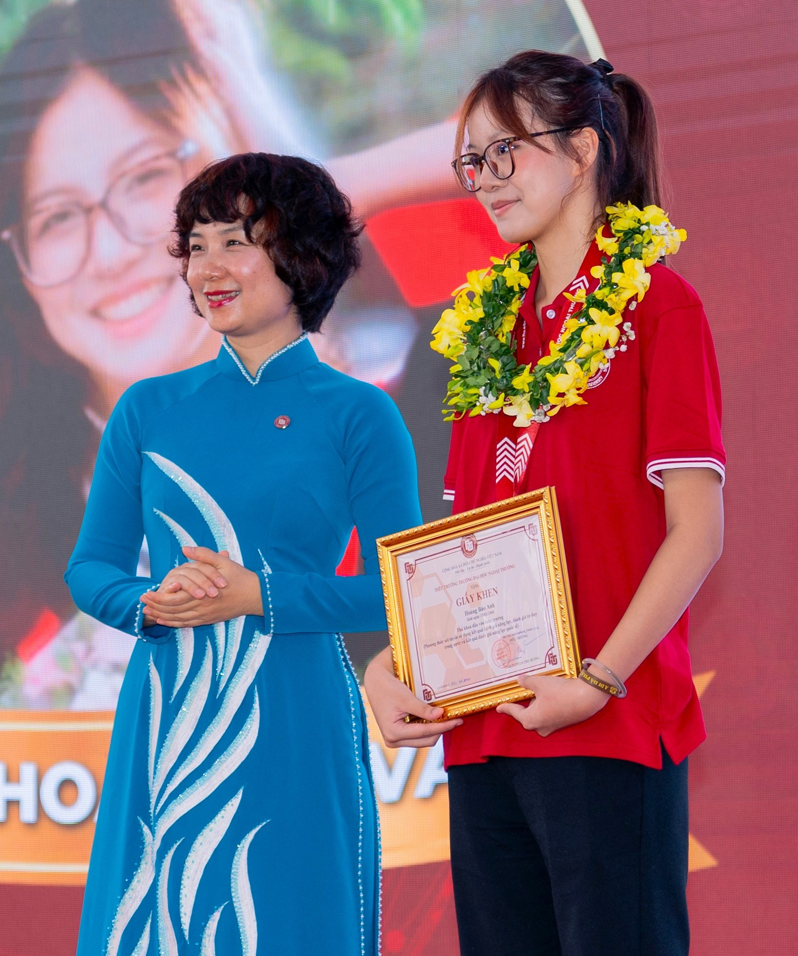 PGS.TS Phạm Thu Hương, Hiệu trưởng Trường ĐH Ngoại thương tặng Giấy khen cho Hoàng Bảo Anh với thành tích thủ khoa đầu vào của trường năm 2026.