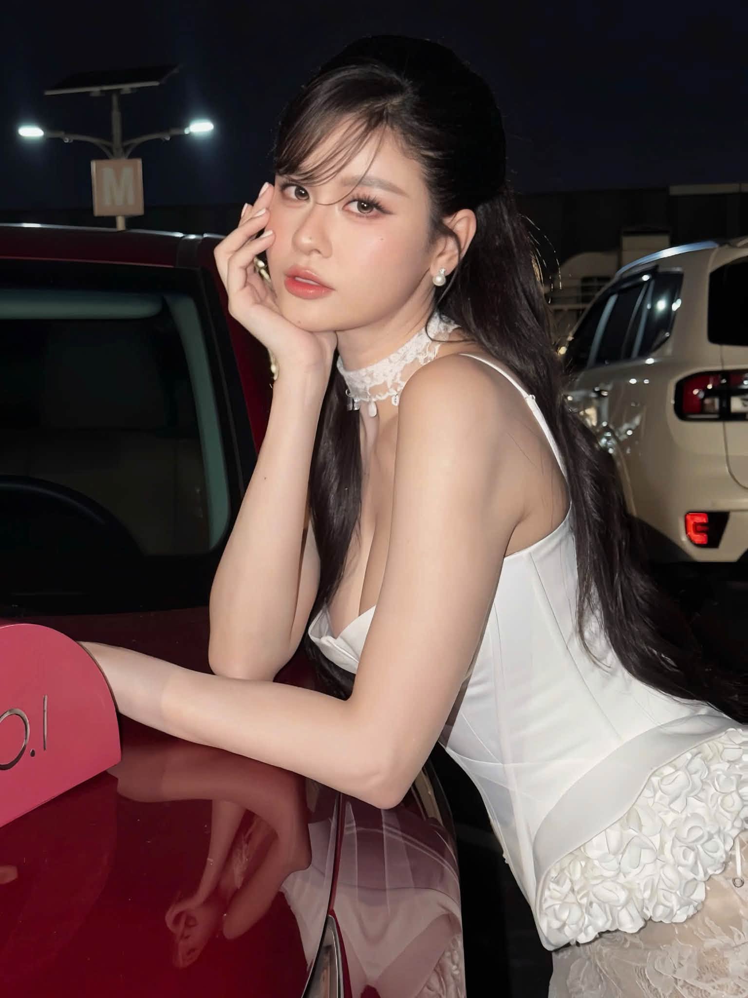 Nữ ca sĩ diện thiết kế tông trắng gồm áo corset ôm sát kết hợp chân váy ren dài. Phần chất liệu ren có độ xuyên thấu vừa phải, tạo hiệu ứng mềm mại nhưng vẫn giữ được sự thanh lịch cho tổng thể.