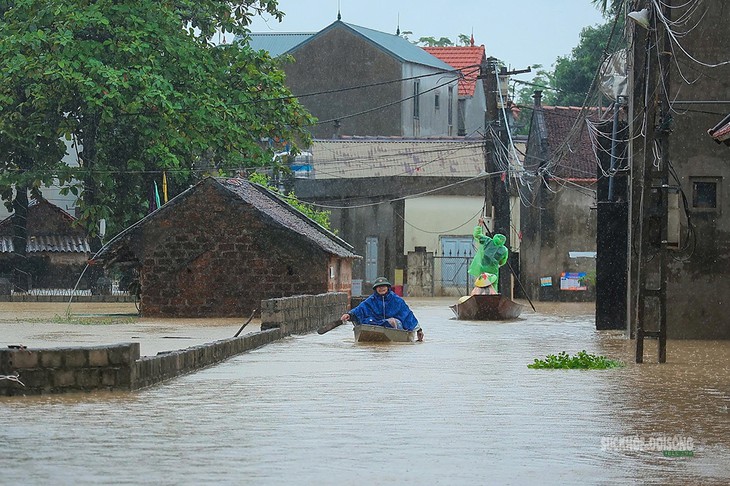 Nước ngập sâu đường làng, thuyền trở thành phương tiện đi lại của người dân Đồng Dâu. Ảnh: T.Anh