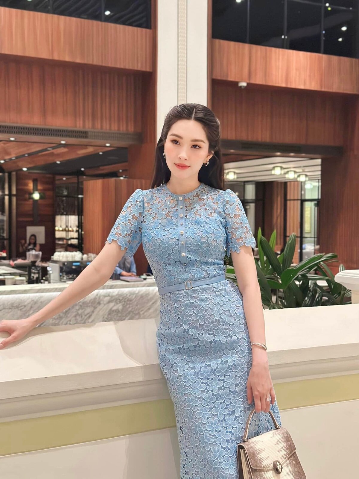 Cùng năm, khi ở Campuchia, người đẹp diện đầm ren hoa xanh dương phong cách công sở, phối túi da thằn lằn của Bvlgari.