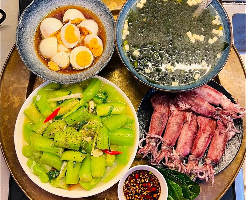 Mâm cơm này gồm các món: Mực hấp, mướp xào, trứng luộc, canh rong biển.