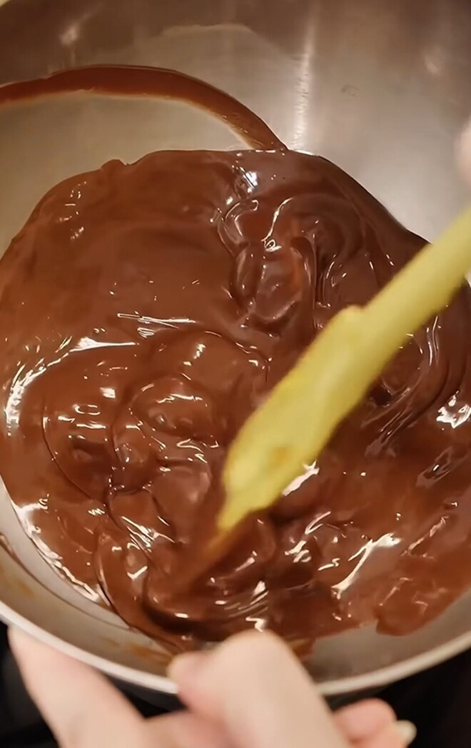 Chocolate được đun chảy hoàn toàn thành một hỗn hợp lỏng, mịn màng và vô cùng thơm ngon, bóng bẩy trên bếp.