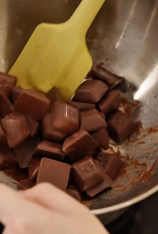 Trong lúc đợi vỏ cam nguội hẳn, nữ MC chuẩn bị khoảng 200g chocolate bẻ nhỏ cho vào bát để chuẩn bị đem đi hấp cách thủy.