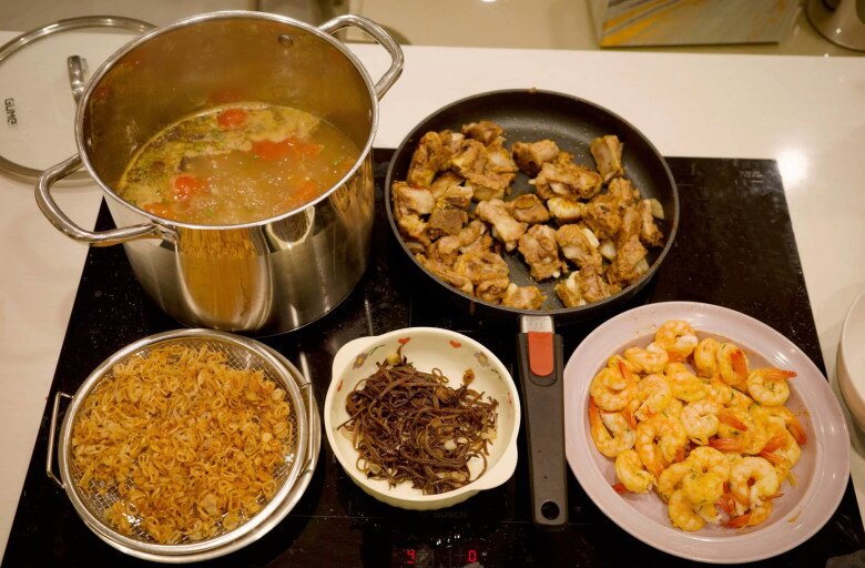 Công đoạn chuẩn bị vô cùng chỉn chu với nước dùng ninh ngọt thanh, sườn chiên vàng gợn sóng, tôm bóc vỏ tươi ngon cùng hành phi, mộc nhĩ thái sợi. Nữ MC chia sẻ: Sườn ninh xong em cho vào chảo đảo sơ với nước mắm và dầu điều, vừa thơm, vừa ngấm vị vừa tạo chút màu hấp dẫn.