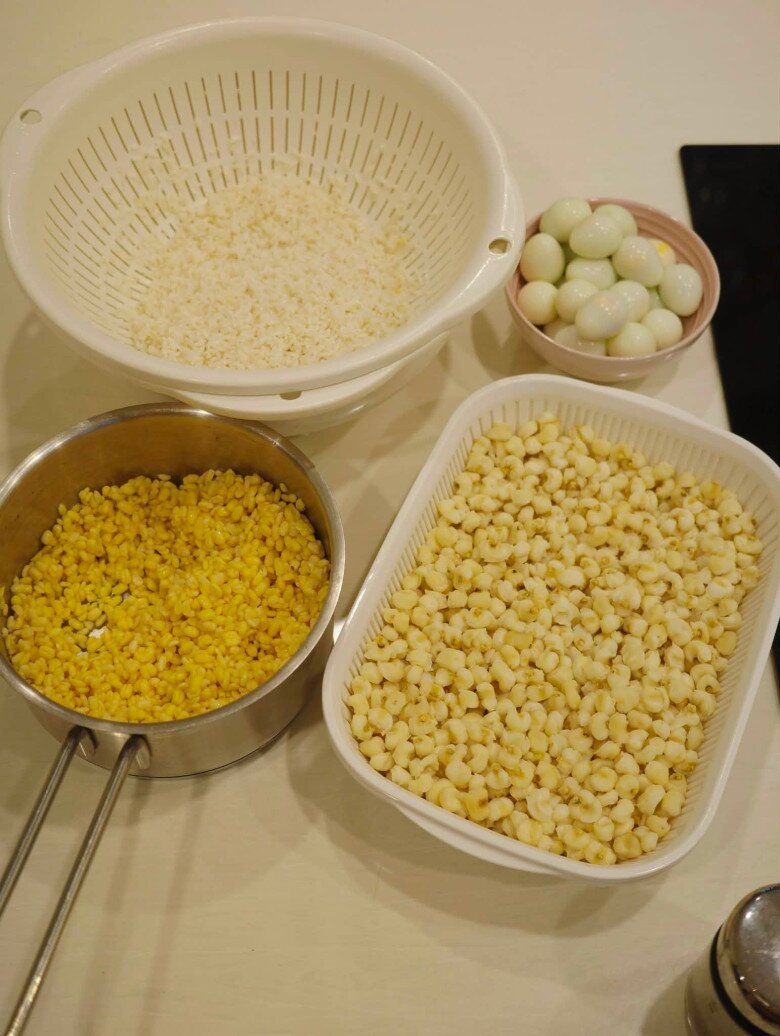 Các nguyên liệu gồm gạo nếp, đậu xanh và ngô bung đều được nữ MC chuẩn bị, ngâm qua đêm chu đáo trước khi đem đồ xôi. Trứng cút cũng được luộc bóc vỏ sẵn sàng cho món thịt kho.