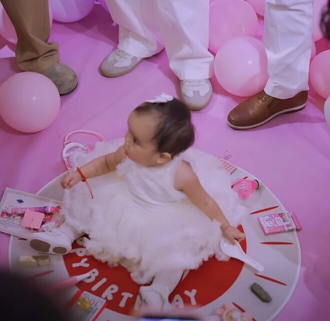 Bé Gạo chọn chiếc thìa trong buổi tiệc thôi nôi.