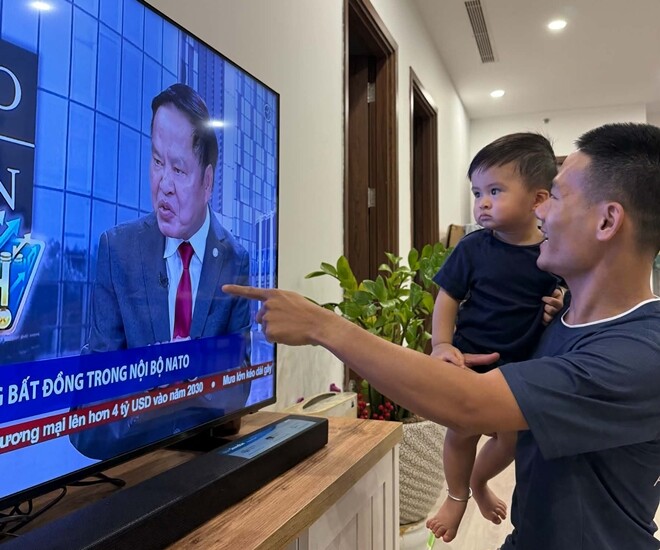 Con trai Hoa hậu Ngọc Hân chăm chú theo dõi ông nội trên tivi. 