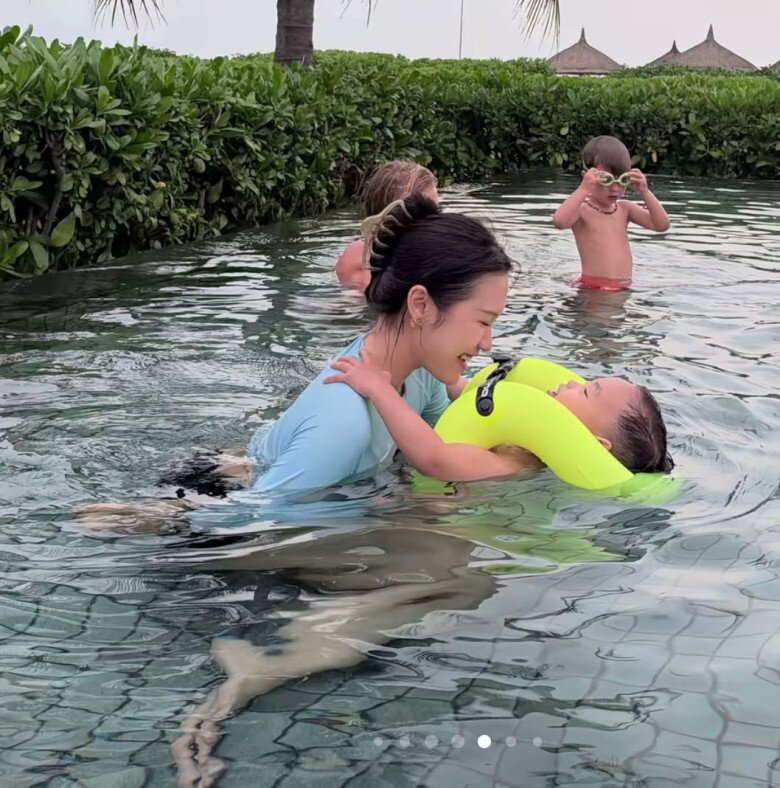 Bà mẹ dành thời gian dạy con trai tập bơi.