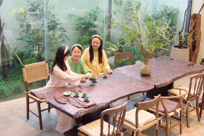 Không gian phòng ăn độc đáo tại biệt thự của Midu với chiếc bàn gỗ nguyên khối dáng tự nhiên cắt xẻ mộc mạc. Góc phòng được bao bọc bởi hệ thống kính lớn hướng ra khoảng sân vườn xanh mát, mang lại cảm giác thư thái và gần gũi với thiên nhiên.