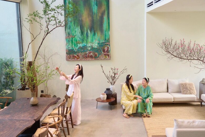 Phòng khách rộng lớn với thiết kế thông tầng thoáng đãng, đón trọn ánh sáng tự nhiên. Nơi đây được trang trí tối giản nhưng đầy nghệ thuật với bức tranh tường khổ lớn nổi bật, kết hợp cùng hoa tươi và cây cảnh, nhất là những dịp lễ Tết càng rực rỡ hơn.