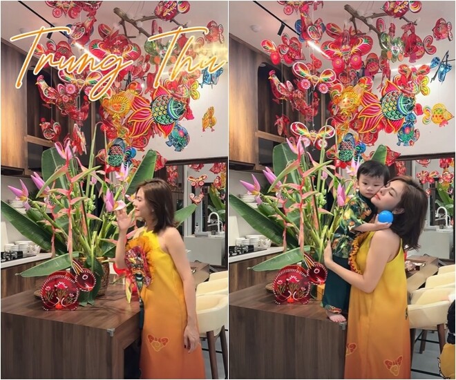 Không gian bếp tràn ngập không khí Tết Trung thu với dàn đèn ông sao, đèn cá chép rực rỡ treo cao. Vân Trang rạng rỡ diện áo dài sắc cam - vàng đồng điệu bên con trai nhỏ, tạo nên khoảnh khắc vô cùng ấm áp và bình yên trong chính ngôi nhà của mình.