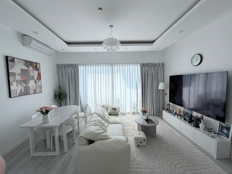 Không gian phòng khách vô cùng rộng rãi, tràn ngập ánh sáng tự nhiên nhờ hệ cửa kính lớn. Căn hộ sử dụng gam màu trắng - xám chủ đạo, kết hợp nội thất tối giản nhưng vô cùng tinh tế.