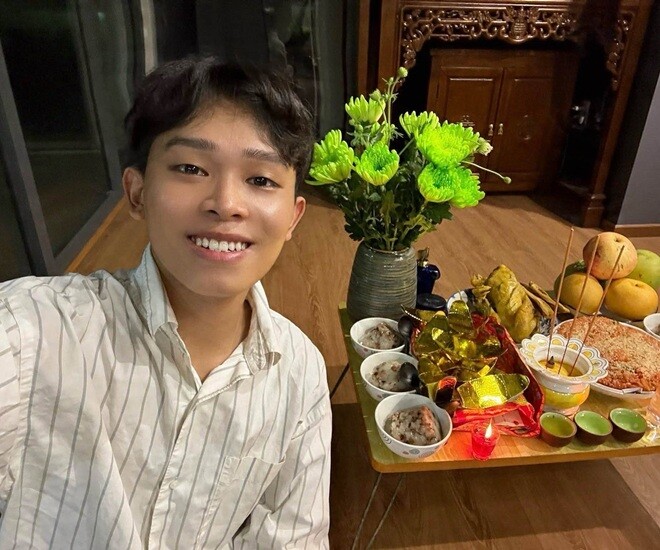 Hồ Văn Cường rạng rỡ chụp ảnh kỷ niệm bên mâm lễ cúng Giỗ tổ sân khấu tươm tất tại nhà. Nam ca sĩ chuẩn bị đầy đủ hoa tươi, gà luộc, xôi cùng trái cây để thể hiện lòng thành kính với nghề.
