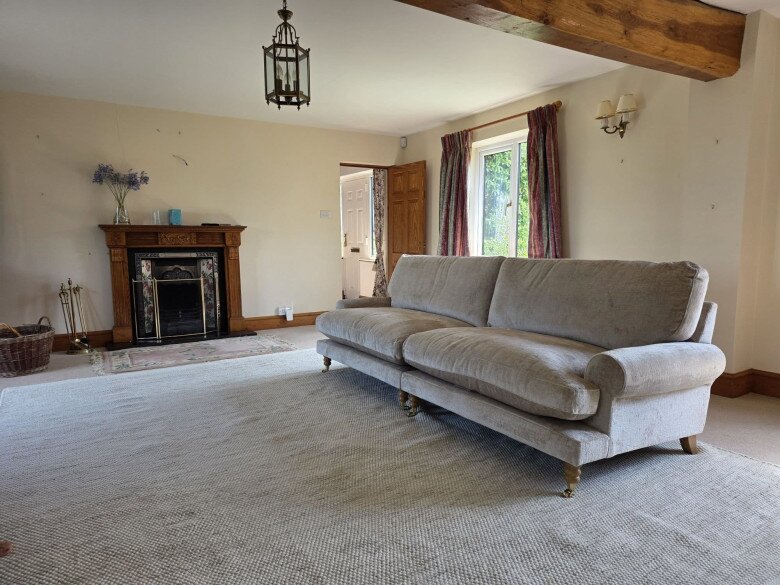 Chiếc sofa bọc nỉ cao cấp màu kem thanh lịch được sắp đặt chỉn chu ngay trung tâm phòng khách. Thiết kế êm ái cùng sắc màu trang nhã hòa hợp hoàn hảo với thảm trải sàn và tổng thể kiến trúc ấm cúng của ngôi nhà.