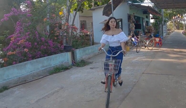 Bối cảnh xung quanh nhà là con đường làng bình yên, phủ đầy hoa giấy rực rỡ. Mỗi lần về quê, Nam Thư lại thích thú chạy chiếc xe đạp cũ đi dạo khắp xóm làng.