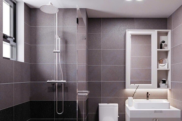 Phòng tắm mang phong cách tối giản với tông màu xám lịch lãm và vách kính ngăn khu vực tắm đứng. Hệ tủ lavabo kết hợp gương soi có ngăn chứa đồ thông minh giúp không gian luôn gọn gàng và ngăn nắp.