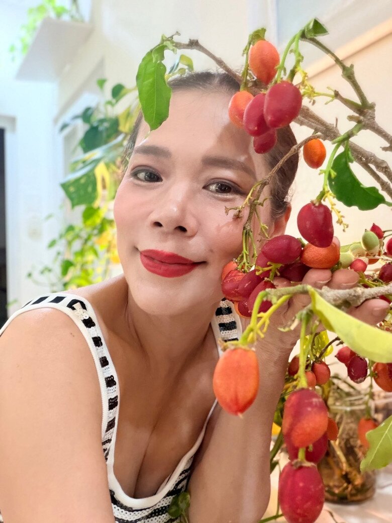 Ca sĩ Mỹ Lệ khoe nụ cười rạng rỡ bên cành quả chín đỏ mọng vừa hái trong vườn. Nữ ca sĩ cho biết chị rất mê trồng các giống cây độc lạ, vừa để thưởng thức trái ngon vừa để trang trí không gian sống thêm sinh động.