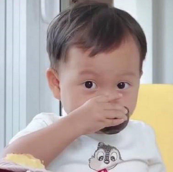 Cậu bé sao chép hành động uống trà của bố (Ảnh cắt từ video).