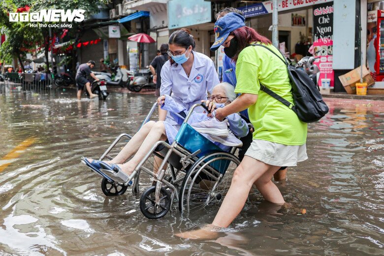 Mưa lớn trút xuống, người dân đi lại khó khăn - 11