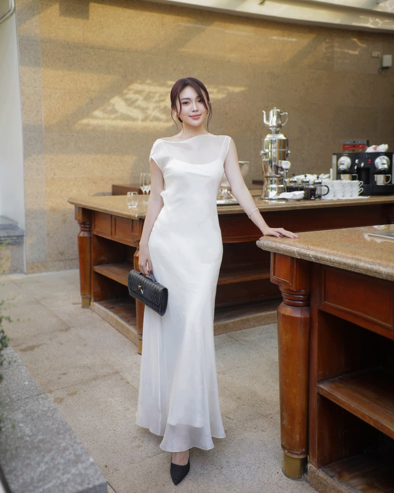 Váy lụa trắng nổi bật giữa background đèn lồng rực rỡ, đồng thời tạo hiệu ứng vóc dáng mềm mại. Chị em có thể chọn váy hai dây hoặc cổ vuông để tăng nét quyến rũ.