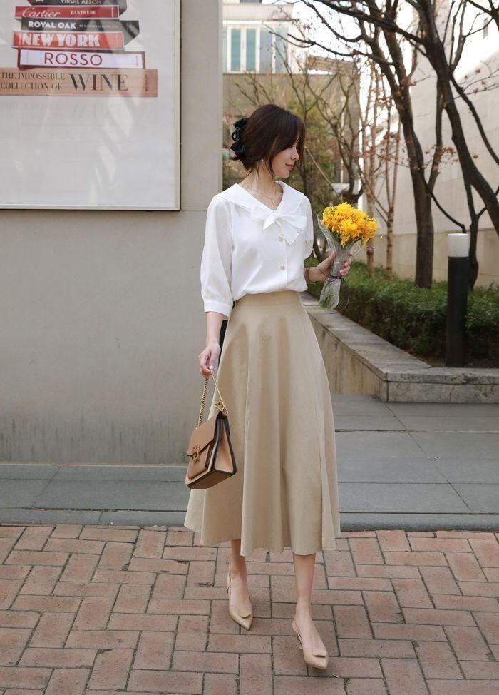 Cách mix amp; match hoàn hảo nhất với chân váy midi là áo sơ mi trắng. Bạn cũng có thể mix item này cùng áo dệt kim dáng ôm hoặc áo len mỏng sơ vin gọn gàng, khoác ngoài một lớp áo blazer hoặc trench coat.
