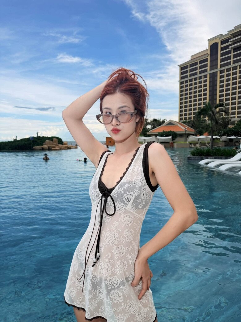 Đông Nhi khoe vóc dáng thon gọn với váy ren trắng gợi cảm bên hồ bơi.