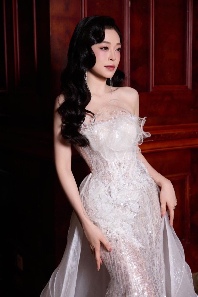 Một thiết kế dạ hội cúp ngực tông trắng ngà tiếp tục cho thấy cách Phương Nga khai thác vẻ đẹp hình thể. Phần thân váy ôm sát cơ thể, sau đó chuyển thành tà rủ mềm, tạo hiệu ứng uyển chuyển khi di chuyển.