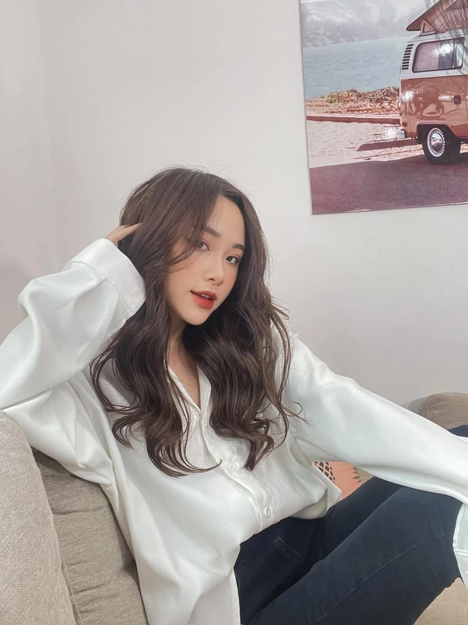 Trong khung hình này, Mai Huê theo đuổi vẻ thanh lịch, hiện đại với sơ mi lụa trắng phom rộng khoác hờ cùng quần ôm tối màu. Cách phối tối giản, kết hợp mái tóc uốn nhẹ, giúp cô giữ được nét nữ tính, thanh thoát mà không kém phần cuốn hút.