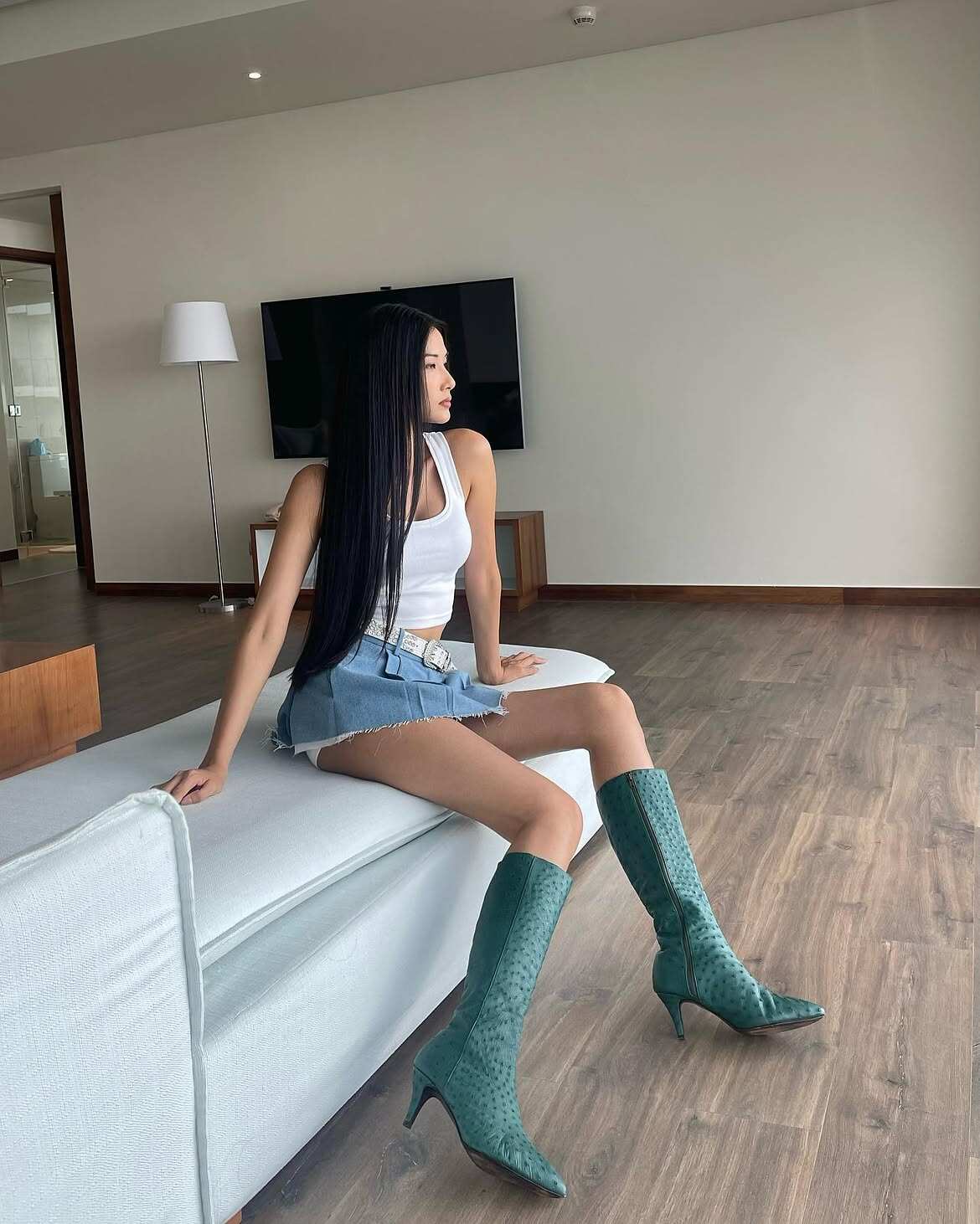 Hoàng Thùy phối tank top cùng chân váy cạp trễ, kết hợp boots để tạo tổng thể cá tính, phóng khoáng.