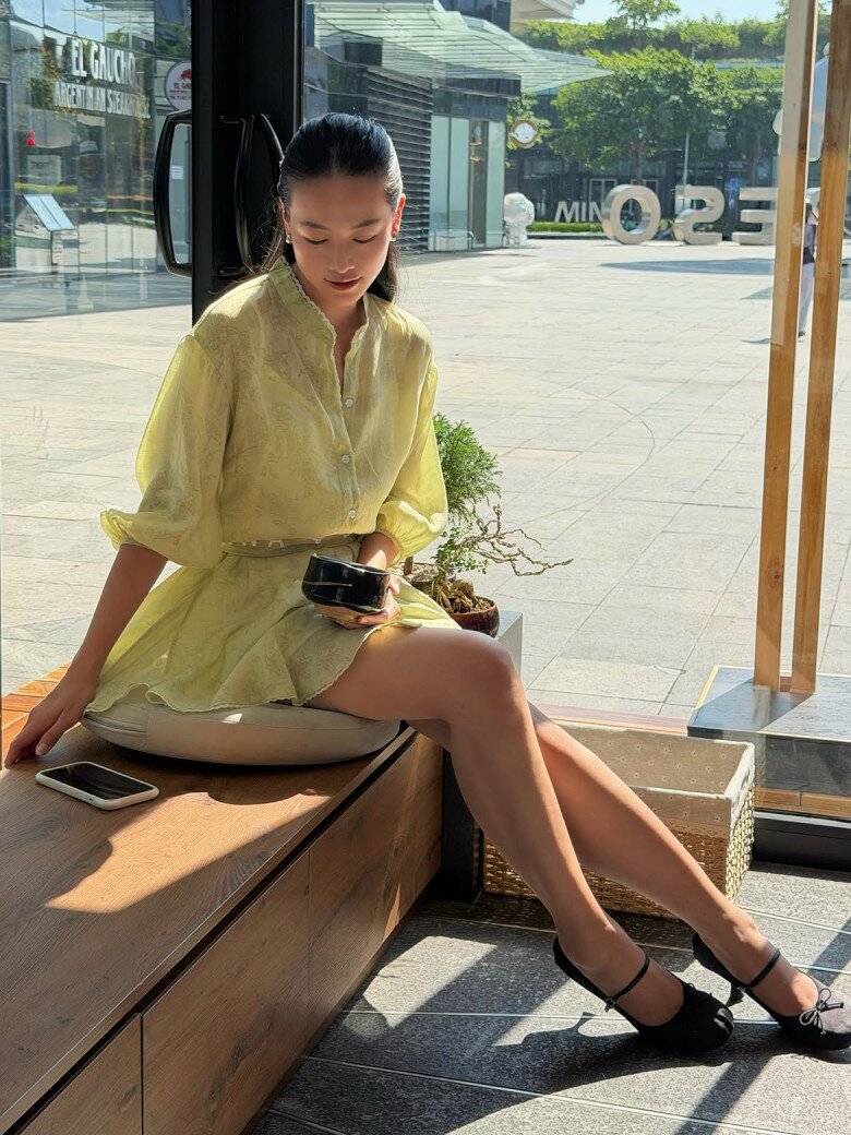 Ở một lần xuất hiện khác, Phương Khánh tiếp tục ghi điểm với set đồ nữ tính gồm áo blouse sáng màu phối chân váy ngắn, kết hợp giày cao gót và túi xách nhỏ. Cách phối đồng điệu giúp tổng thể giữ được vẻ thanh thoát mà không cần quá nhiều phụ kiện.