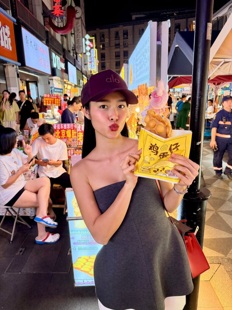 Xuống phố, Diệp Bảo Ngọc chọn áo quây xám đậm phối cùng trang phục trắng, khoe bờ vai thon gọn. Mũ lưỡi trai tím mận và túi xách đỏ tạo điểm nhấn, hoàn thiện vẻ ngoài năng động, trẻ trung.