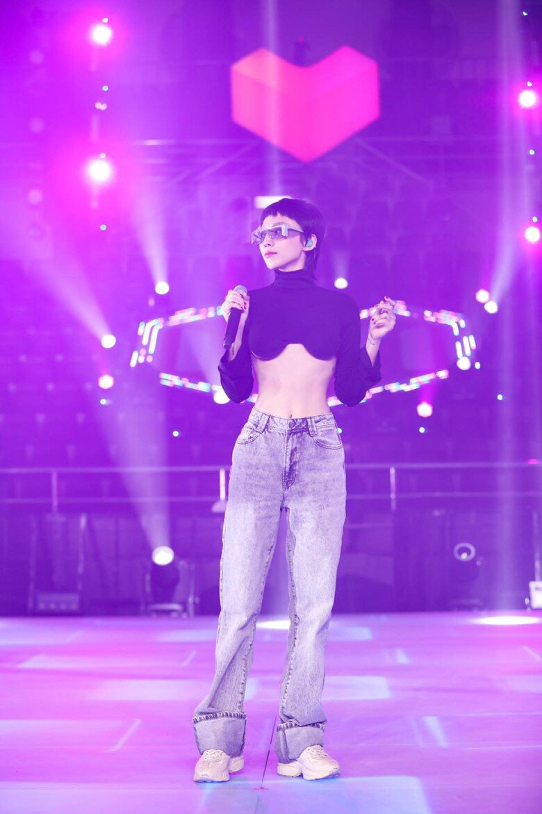 Ở một lần xuất hiện khác, Tóc Tiên nổi bật với áo croptop cổ cao tay dài màu đen, cắt hở chân ngực quyến rũ, kết hợp cùng quần jeans ống suông lưng cao màu xám nhạt phai màu và giày sneaker trắng.