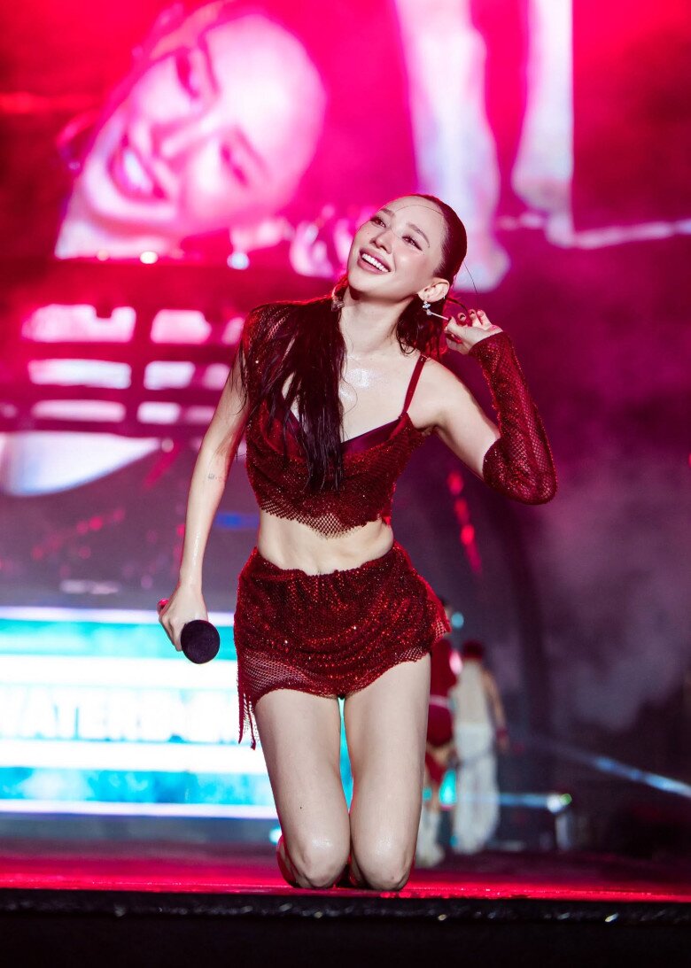 Minh chứng cho phong cách trình diễn bùng nổ của Tóc Tiên là set đồ đỏ rực trên sân khấu. Thiết kế hai mảnh phủ lớp lưới đính kim tuyến tôn đường cong và cơ bụng săn chắc, kết hợp ống tay đồng điệu, giúp nữ ca sĩ nổi bật dưới ánh đèn mà vẫn thoải mái thực hiện các động tác vũ đạo.