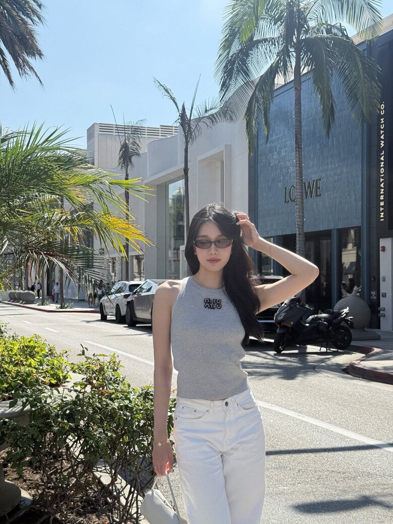 Áo tank top ôm dáng kết hợp quần jeans trắng giúp tôn vóc dáng thanh thoát của Phương Anh.