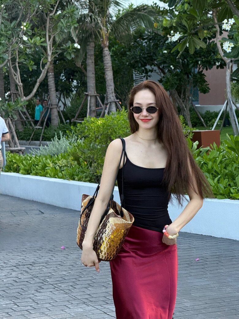 Với ouffit này, cô lại chọn chân váy tone đỏ rực rỡ mix cùng áo 2 dây màu tối.