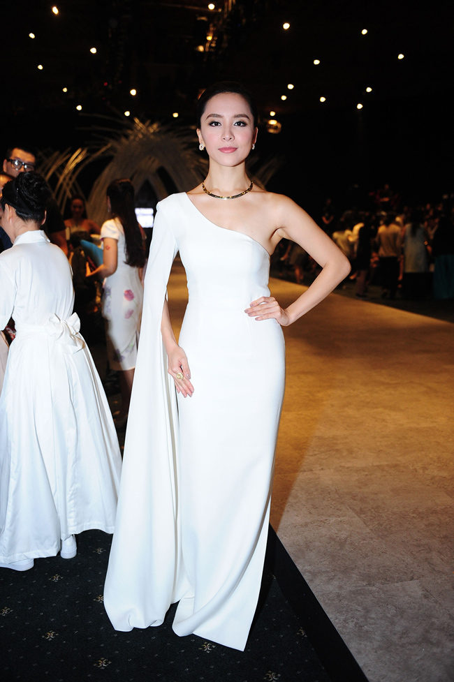 Á hậu Dương Trương Thiên Lý diện đầm lệch vai màu trắng khoe vẻ đài các trên hàng ghế đầu Vietnam International Fashion Week.
