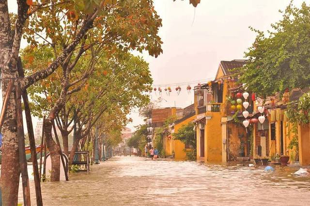 Phố cổ Hội An chìm trong nước lũ, người dân và du khách chèo xuồng để di chuyển - 8
