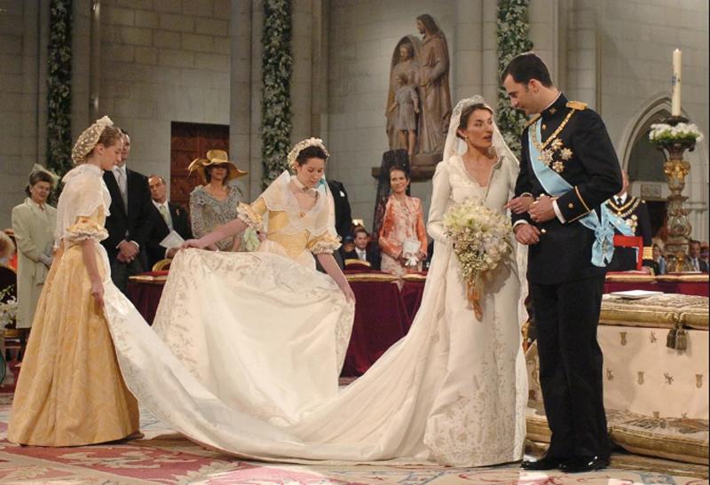 Hoàng hậu Letizia Ortiz lựa chọn váy cưới trắng với đuôi váy dài khoảng 4.5m trong đám cưới của bà và Thái tử Felipe của Tây Ban Nha. Cổ tay áo, cổ áo và các đường riềm được thêu thủ công bằng tay.

