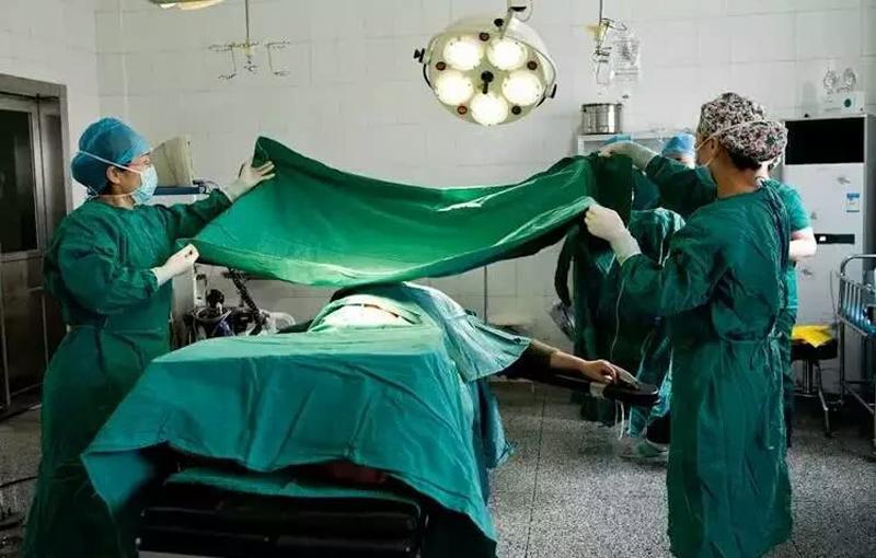 Cả cơ thể người mẹ được phủ một tấm vải khử trùng, chỉ để hở ra vùng bụng để bác sĩ thực hiện phẫu thuật. 
