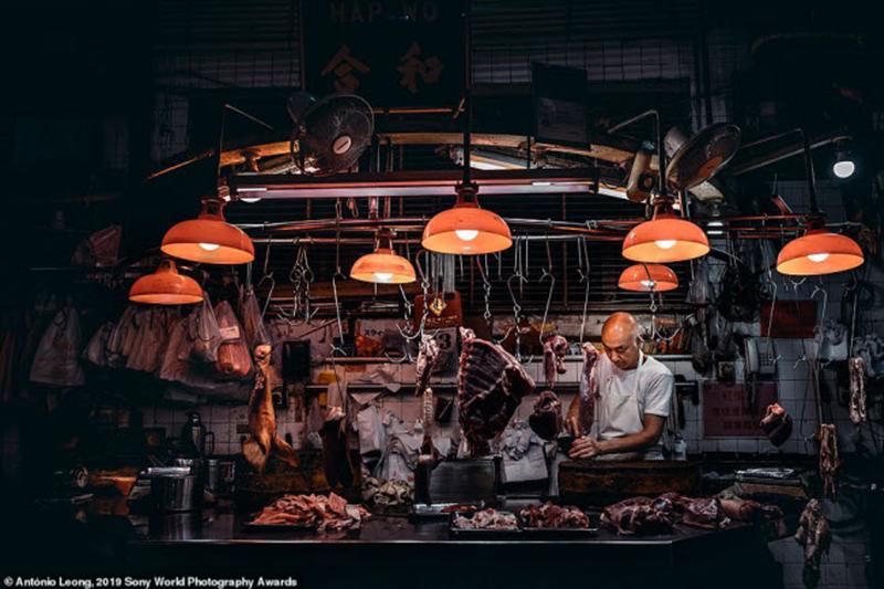 Người bán thịt chuẩn bị đóng cửa hàng sau một ngày làm việc dài tại khu chợ Đỏ ở Ma Cao, Trung Quốc. Ảnh: António Leong
