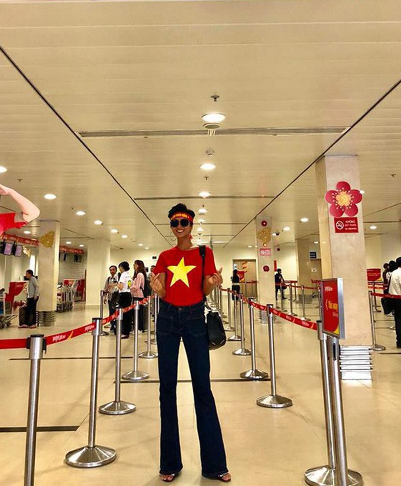 Hoa hậu H' Hen Niê giữ nguyên phong cách thời trang cá tính, với áo cờ đỏ sao vàng phối cùng quần ống rộng. Thiết kế với chất liệu jeans năng động đồng thời giúp kéo dài đôi chân của cô. 
