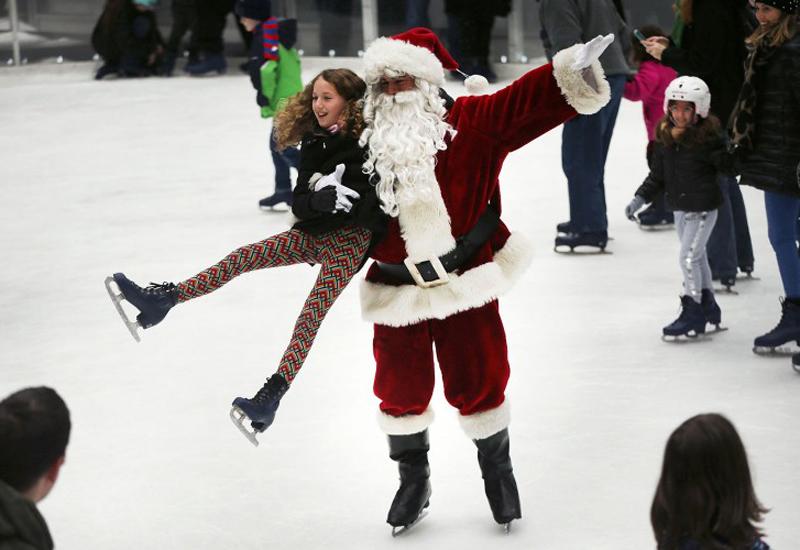 Ông già Noel bế bổng bé gái trong lúc trượt băng tại sân trượt băng The Rink at Rockefeller Center, thành phố New York, Mỹ ngày 14/12.
