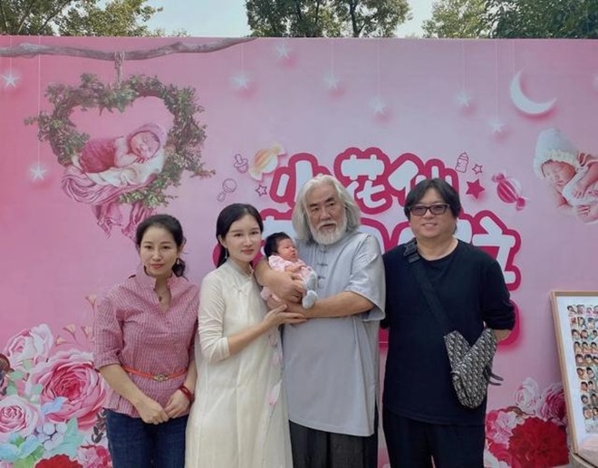 Đạo diễn U70 tóc bạc phơ bế con ẵm ngửa nhưng không sốt bằng cô vợ bé bên cạnh - 1