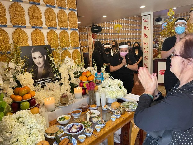 Con gái Phi Nhung đứng cạnh di ảnh mẹ, cúi đầu cảm tạ những vị khách đến viếng.