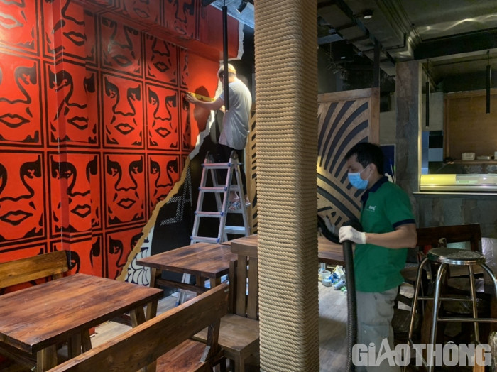 Nhân viên làm vệ sinh hút bụi, sửa sang trang trí bên trong hàng.